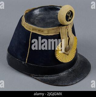 Huvudbonad harnais militaire, Käppi, m/1854, pour équipage à l'infanterie. Tissu bleu foncé avec toit de la colline et écran en cuir laqué noir. Au niveau du grand gallon supérieur autour du bord. À l'avant, l'agraff sous la forme d'un grand cuisinières de modèle pressé jaune - cuir peint avec la surface large gallons et bouton avec trois couronnes. Pompong rond de corde avec compagnie ou bataillon figure 2 en laiton. La mentonnière en cuir noir et le laçage au contrôle de la taille sont manquants. Banque D'Images