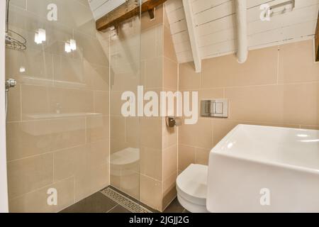 Salle de bains et toilettes élégantes avec lavabo en pierre et chambre ouverte au sol grenier dans un appartement moderne Banque D'Images