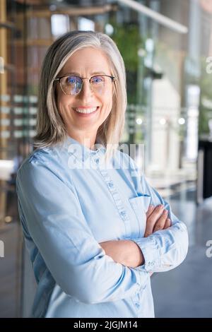 Portrait Verticasl de souriante confiante 60-s gris-cheveux mature femme. Banque D'Images