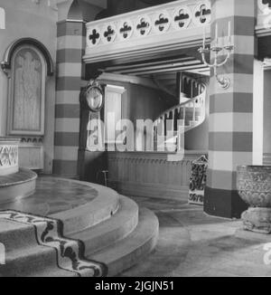 Église Kyrka Bräkne-Hoby. Détails intérieurs avec la police baptismale du 13th siècle dans le bord droit de l'image et horloge au sol dans l'arrière-plan. Banque D'Images