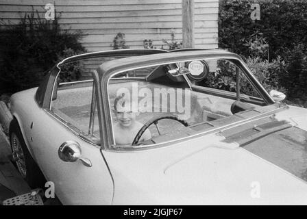 Un garçon d'année de feu dans un bain à remous de voiture de Lotus, Medstead, Alton, Hampshire, Angleterre, Royaume-Uni. Banque D'Images