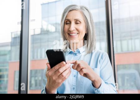 Gros plan sur une femme d'affaires qui utilise un smartphone dans un bureau. Banque D'Images