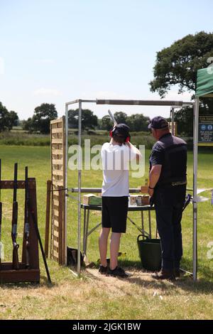 The Royal Cheshire County Show, Knutsford, Angleterre, Royaume-Uni. - 22 juin 2022: Un jeune homme instruit en tir de pigeon d'argile sur la plage de tir. Banque D'Images