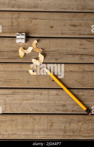 Image verticale de crayon, taille-crayon et peelings sur fond en bois Banque D'Images