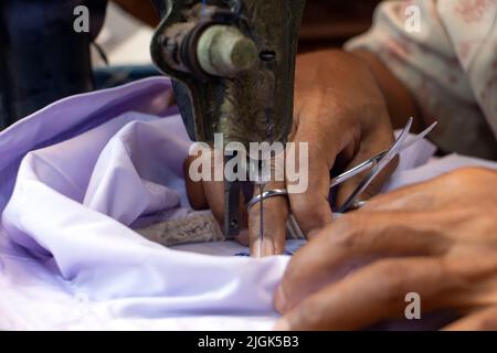 Broder des numéros thaïlandais sur une chemise d'étudiant sur une vieille machine à coudre Banque D'Images