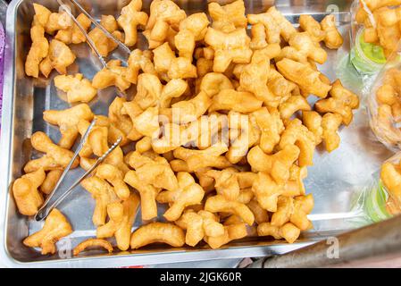 L'offre d'un bâton de pâte frite au marché thaïlandais, gros plan. Banque D'Images