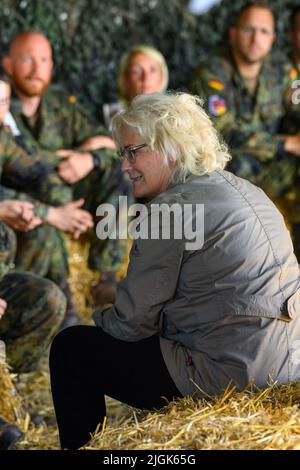 11 juillet 2022, Saxe-Anhalt, Gardelden/OT Letzlingen: La ministre allemande de la Défense, Christine Lambrecht (SPD), s'assoit avec des soldats dans une tente au centre d'entraînement au combat de l'armée. Le ministre a visité l'installation d'entraînement près de Gardeden pour voir comment les soldats sont préparés à leur déploiement. Environ 700 hommes et femmes y sont actuellement en formation pour un déploiement au Mali en Afrique de l'Ouest. Photo: Klaus-Dietmar Gabbert/dpa Banque D'Images