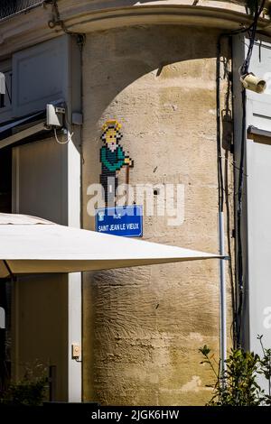 Un homme âgé avec une canne en carrelage mosaïque décore un mur de maison à côté du panneau de signalisation "Rue Saint Jean Le Vieux" à Avignon, France – probablement un jeu de mots de l’artiste de rue anonyme français MifaMosa sur le nom de la rue, qui signifie "Rue de Saint Jean l’Ancien". Depuis 2017, MifaMosa a installé plus de 300 mosaïques thématiquement assorties à côté des panneaux de signalisation, notamment à Orléans, Lyon, Montpellier et Lille ; trois petits points sur l’œuvre représentent lui-même, sa mère et sa sœur. Banque D'Images