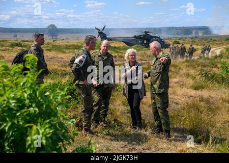 11 juillet 2022, Saxe-Anhalt, Gardelden/OT Letzlingen: Lieutenant-colonel René Braun (2vl-r) du Centre d'entraînement au combat de l'armée, général Ruprecht von Butlar, commandant de la division 10th Armored, ministre de la Défense fédérale Christine Lambrecht (SPD) et colonel Michael Knoke, Le chef du Centre d'entraînement au combat s'est parlé en marge d'un exercice au Centre d'entraînement au combat de l'Armée de terre. À l'installation d'entraînement près de Gardeldelden, le ministre a eu une idée de la façon dont les soldats sont préparés à leur déploiement. Environ 700 hommes et femmes y sont actuellement formés pour leur déploiement Banque D'Images