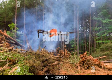 Des drones sont utilisés par les pompiers pour surveiller le feu lorsqu'il se déplace à travers les arbres de la forêt Banque D'Images