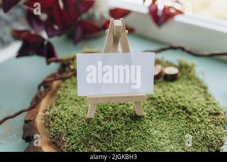 maquette de carte de visite dans le style de la nature, papier blanc sur mousse verte et coupe de bois Banque D'Images