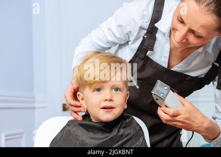 Tondez votre coiffeur avec les poils professionnels d'un petit garçon Banque D'Images