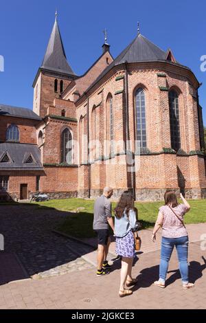 Visiteurs à l'église gothique du 14th siècle, église Saint-Jean, extérieur de Tartu, lors d'une journée ensoleillée d'été, Tartu Estonie Europe Banque D'Images