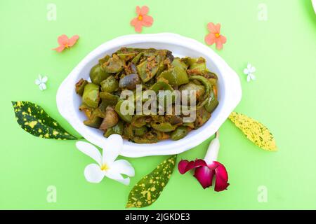 Délicieux cari au poivron vert ou au poivron vert. Remuez avec des oignons sautés sabaji asiatique indien avec du masala. Sur fond rouge, l'image de la nourriture est un espace de copie de Banque D'Images