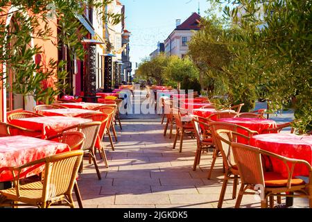 Tables avec des nappes rouges sur la terrasse extérieure du restaurant sur la rue touristique, Gyor, Hongrie Banque D'Images