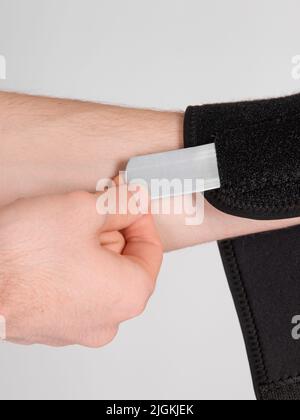 Orthèse de bras. Concept de poignet cassé. Projeter un bras et un poignet cassés pour immobiliser le bras et la main. Homme utilisant une attelle de pouce. Inflammation du Banque D'Images