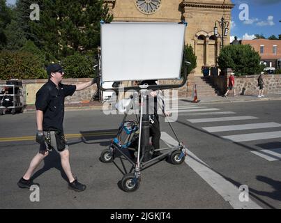 Un membre d'une équipe d'éclairage de film, une poignée, déplace une lumière LED Softlight ARRI SkyPanel après avoir tourné une scène sur place à Santa Fe, Nouveau-Mexique. Banque D'Images