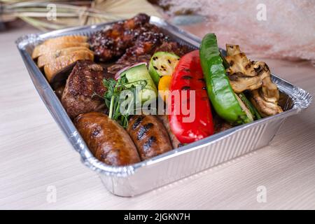 livraison de plats de viande dans une boîte en aluminium. Banque D'Images