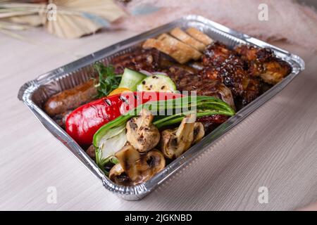 livraison de plats de viande dans une boîte en aluminium. Banque D'Images