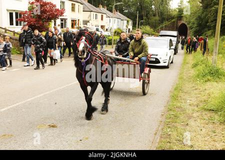 Un coB noir de gitans tirant deux jeunes hommes dans un piège le long de la route, Appleby Horse Fair, Appleby dans Westmorland, Cumbria Banque D'Images