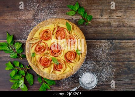 Une tarte maison cuite avec des pommes est exposée sur une table en bois. Banque D'Images