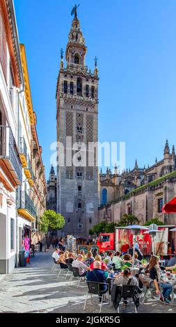 Séville, Espagne - 15 mars 2013 : le clocher de la Giralda de la cathédrale de Séville et les personnes dans un café en plein air à proximité Banque D'Images