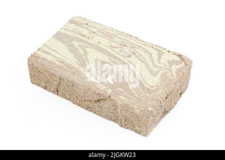 Gros morceau de tahini halva sombre isolé sur fond blanc. Délicatesse turque Banque D'Images