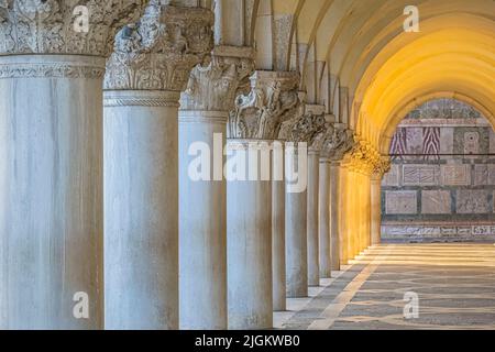 Une rangée de colonnes aux rayons du soleil se brisant au Palais des Doges à Venise, en Italie Banque D'Images