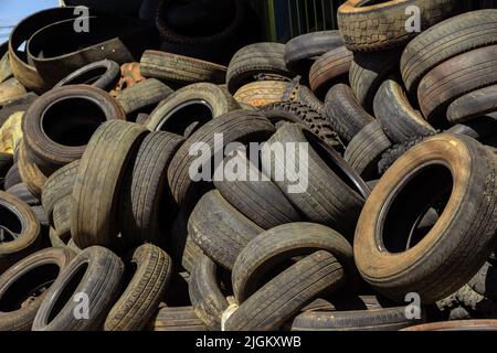 Goiás, Brésil – 10 juillet 2022 : beaucoup de pneus vieux et sales de différentes tailles sont empilés dans un magasin spécialisé. Pneus en caoutchouc, utilisés. Banque D'Images