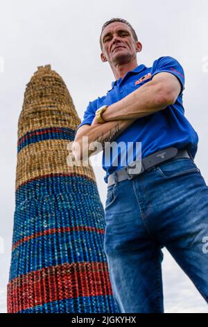 Larne, Irlande du Nord, Royaume-Uni, Royaume-Uni. 11th juillet 2022 - Un membre du comité des feux de camp se tient à côté du feu de camp de Craigyhill, qui a été officiellement déclaré le plus haut du monde à une hauteur de 203 pieds (61,8m) Banque D'Images