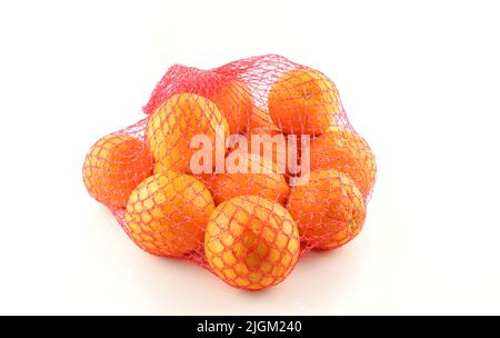 Oranges dans un sac en filet rouge isolé sur fond blanc Banque D'Images