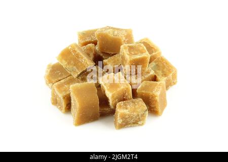 Pile de cubes de sucre brun isolés sur fond blanc. Pile de caramel de noyer et de lait Banque D'Images