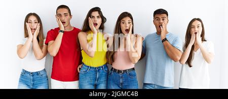 Groupe de personnes portant des vêtements décontractés debout sur un arrière-plan isolé peur et choqué, surprise et l'expression étonnante avec les mains sur le visage Banque D'Images