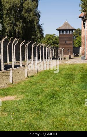 Clôtures de barbelés et tour de garde dans l'ancien camp de concentration nazi d'Auschwitz I, Auschwitz, Pologne. Banque D'Images
