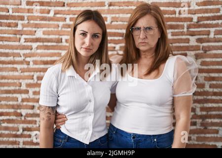 Mère hispanique et fille portant décontracté t-shirt blanc sceptique et nerveux, frowning bouleversé à cause du problème. Personne négative. Banque D'Images