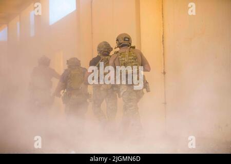 Tifnit, Maroc. 26th juin 2022. Des bérets verts américains affectés au groupe des forces spéciales 19th (aéroporté) de la Garde nationale de l'armée de l'Utah entrent dans un bâtiment après avoir braché la porte pendant l'entraînement à Tifnit, au Maroc, pendant l'African Lion 22, au 26 juin 2022. Le Lion africain 22 est le plus grand exercice annuel combiné, conjoint, du Commandement de l'Afrique des États-Unis organisé par le Maroc, le Ghana, le Sénégal et la Tunisie, 6 juin - 30. Plus de 7 500 participants de 28 pays et de l'OTAN s'entraînent ensemble en mettant l'accent sur l'amélioration de la préparation des forces américaines et des pays partenaires. AL22 est une liaison multidomaine, multicomposant et multizone Banque D'Images