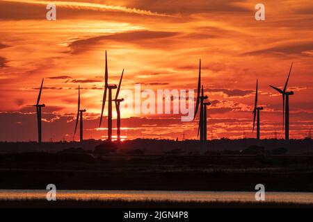 Juillet ciel coucher de soleil derrière le parc éolien Little Cheyne court sur le marais Romney à la frontière est de Sussex Kent, au sud-est de l'Angleterre Banque D'Images