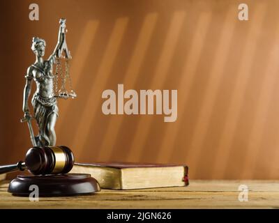 Les symboles d'un tribunal équitable sont la Constitution, le gavage d'un juge et une statuette de bronze de Themis, la déesse de la justice, sur fond beige Banque D'Images