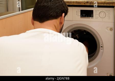 Homme lavant des vêtements. Concept de la hausse des prix de l'énergie. Concept de consommation d'électricité Banque D'Images