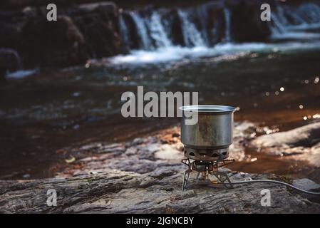 Cuisiner de la nourriture en utilisant le gaz de camping pendant la randonnée. Banque D'Images