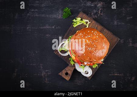 Hamburger au poulet hamburger à la viande, au fromage, à la tomate, au concombre et à la laitue sur fond de bois. Hamburger savoureux. Gros plan. Vue de dessus Banque D'Images