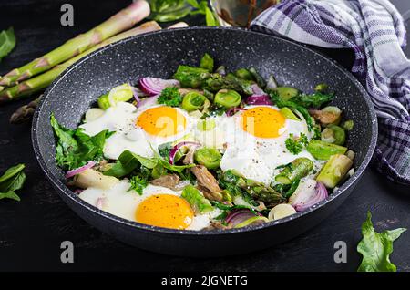 Œufs frits avec asperges, poireaux, épinards et champignons. Petit déjeuner utile. Banque D'Images