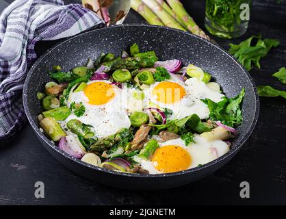 Œufs frits avec asperges, poireaux, épinards et champignons. Petit déjeuner utile. Banque D'Images