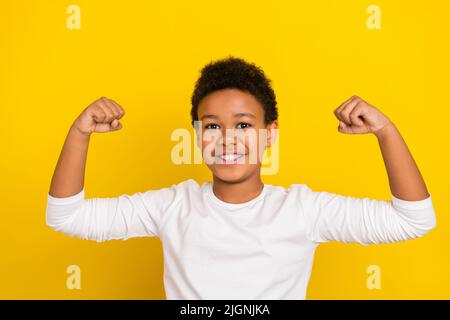 Portrait des bras de pupille positifs et confiants montrent des biceps flexibles isolés sur fond jaune Banque D'Images