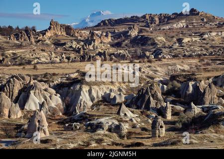 Formations rocheuses en Cappadoce, Turquie, avec Mt Erciyes au loin. Banque D'Images