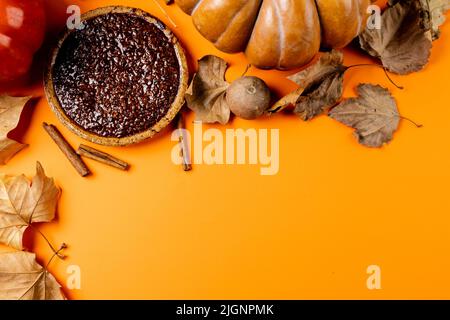 Composition de citrouilles, feuilles d'automne, cannelle et tarte sur fond noir Banque D'Images