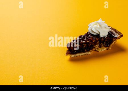 Composition d'un morceau de tarte à la crème fouettée sur fond orange Banque D'Images