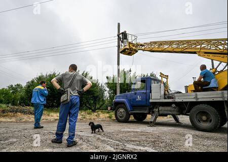 Les employés des services publics réparent une ligne électrique endommagée par des bombardements russes, village de Prymorske, région de Zaporizhzhia, sud-est de l'Ukraine, 11 juillet, 2022. L'Ukraine a mis en garde les habitants du sud de Kherson et de Zaporizhzhia d'évacuer alors qu'elle se prépare à lancer une contre-offensive pour reprendre la zone. Les régions de Kherson et de Zaporizhzhia ont été rapidement occupées par les troupes russes fin février après avoir traversé le pont depuis la Crimée, annexée par la Russie. Photo de Dmytro Smoliyenko/Ukrinform/ABACAPRESS.COM Banque D'Images