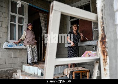 Les femmes sont vues à l'extérieur de leur maison endommagées par les bombardements russes, village de Prymorske, région de Zaporizhzhia, sud-est de l'Ukraine, 11 juillet, 2022. L'Ukraine a mis en garde les habitants du sud de Kherson et de Zaporizhzhia d'évacuer alors qu'elle se prépare à lancer une contre-offensive pour reprendre la zone. Les régions de Kherson et de Zaporizhzhia ont été rapidement occupées par les troupes russes fin février après avoir traversé le pont depuis la Crimée, annexée par la Russie. Photo de Dmytro Smoliyenko/Ukrinform/ABACAPRESS.COM Banque D'Images