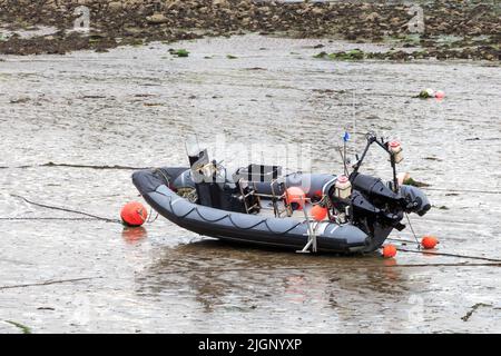 Dinghy noir et gris avec deux moteurs hors-bourd reposant sur la boue à marée basse Banque D'Images